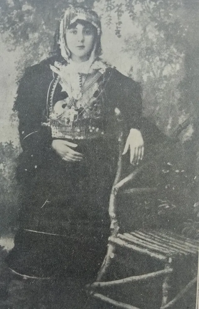A 1913 studio portrait of a young woman of Gjakova in elaborate traditional costume and coin jewellery.