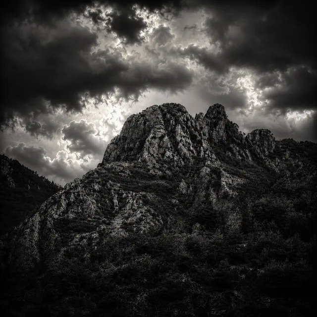A craggy peak of the Accursed Mountains under heavy storm cloud.