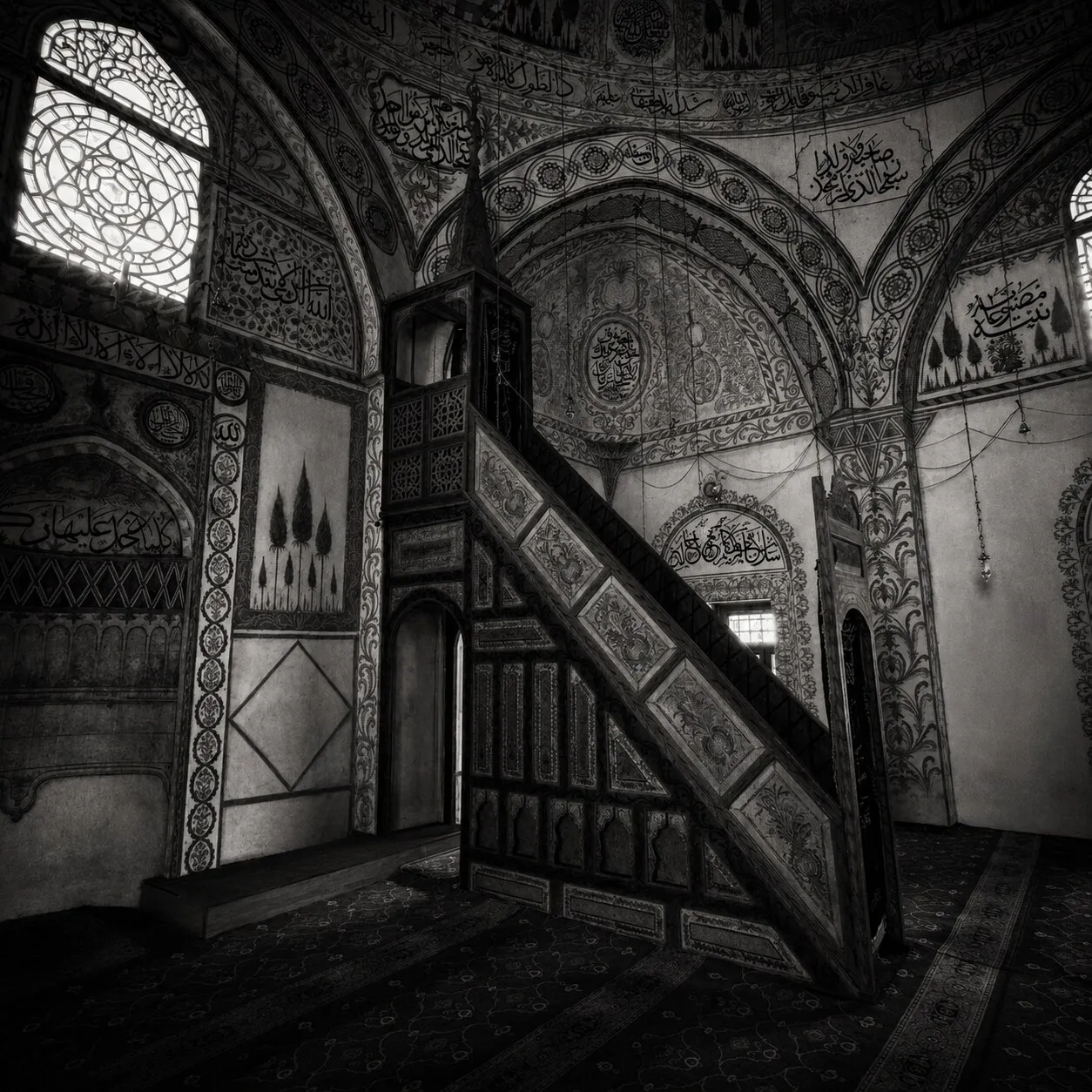The painted interior of the Hadum Mosque — its carved wooden minber and walls of calligraphy.