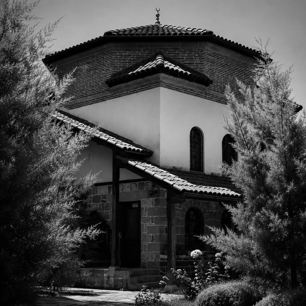 The rebuilt octagonal Hadum library building among trees, its tiled roof and stone base.